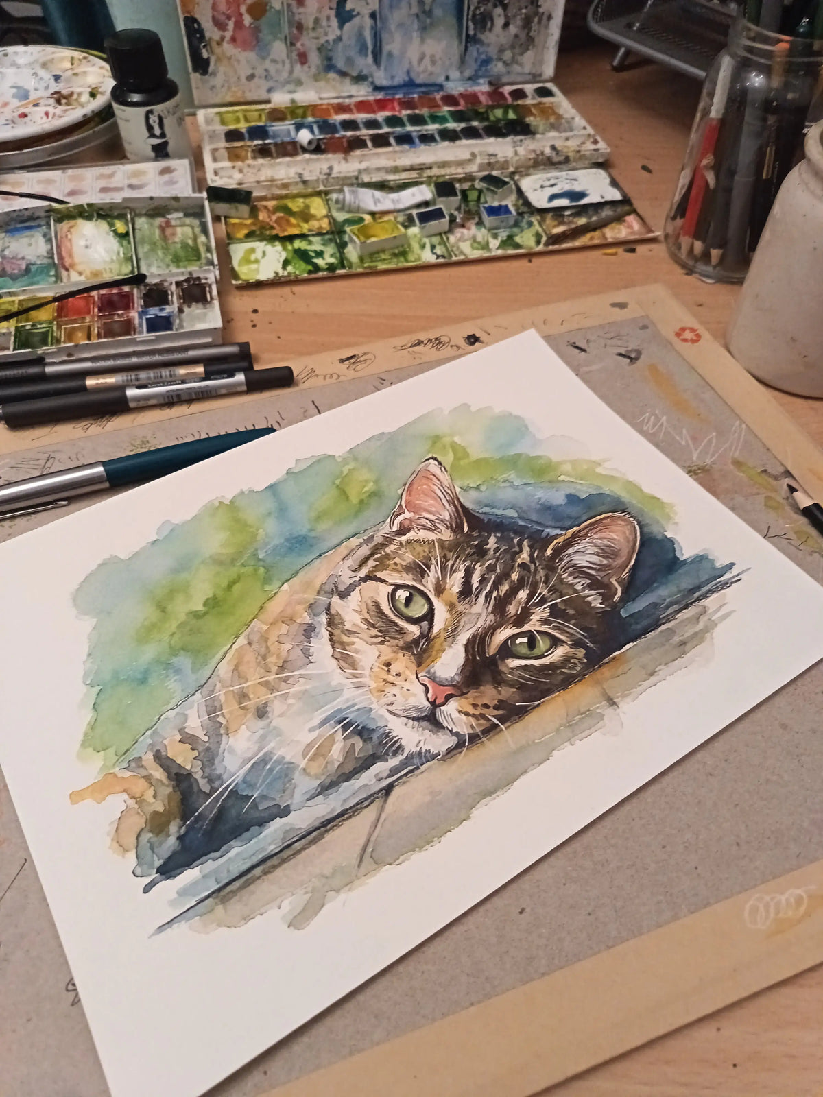 Art on a Wall cat watercolour portrait on a desk with art supplies